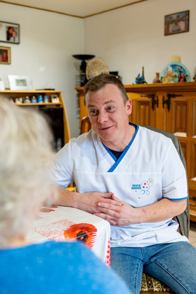 Infirmier Quentin Haubruge qui discute avec une patiente avec le sourire